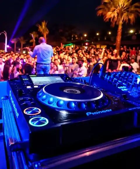 Consolle DJ e pubblico durante un evento serale